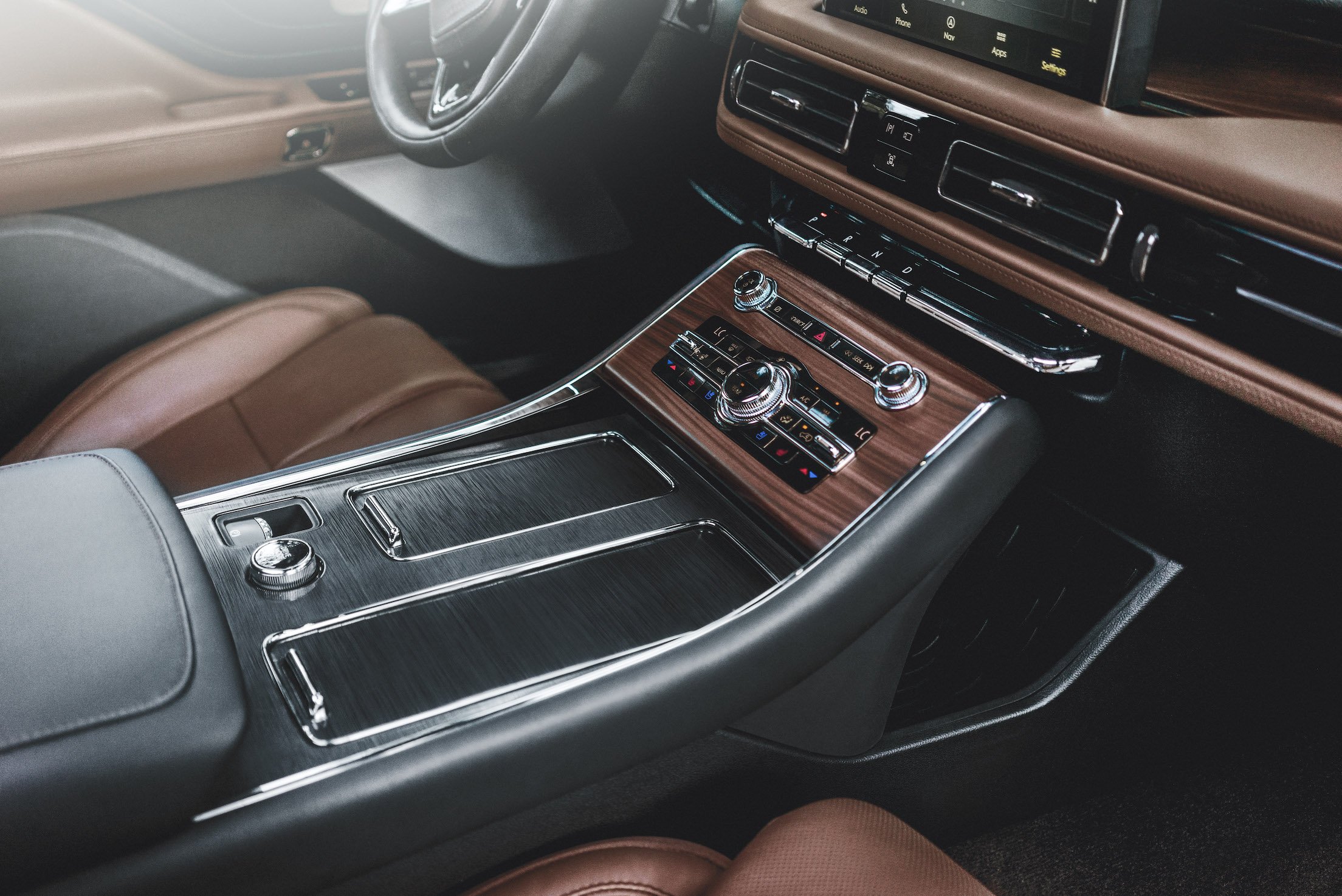The dashboard and center console of a 2019 Lincoln Aviator, showing wood-and-leather trim with chrome accents.