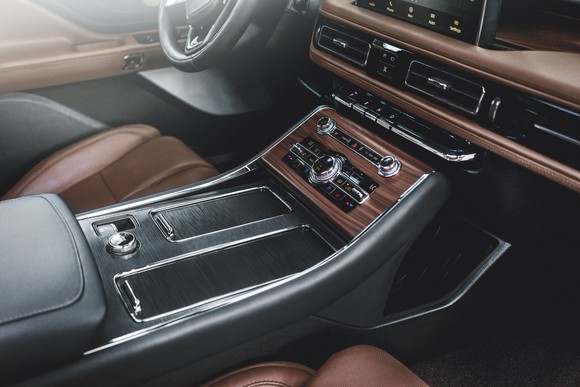 The dashboard and center console of a 2019 Lincoln Aviator, showing wood-and-leather trim with chrome accents.