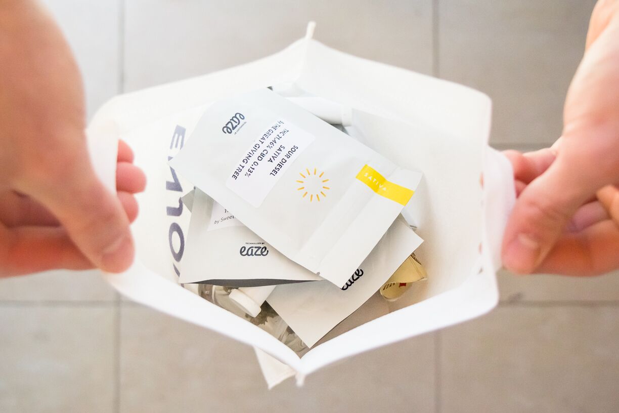 A person holding open a delivered bag of pot products from Eaze.