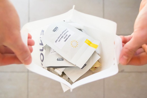 A person holding open a delivered bag of pot products from Eaze.
