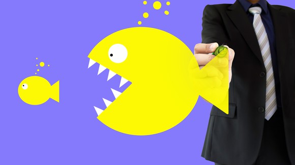 Man in suit drawing big fish about to swallow small fish.