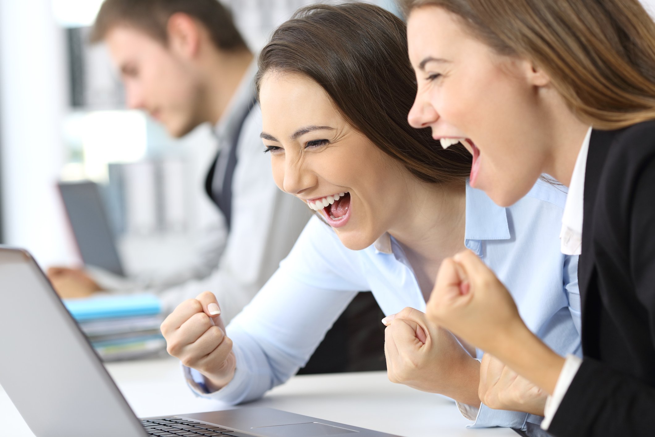 Two workers appear happy looking at a laptop.