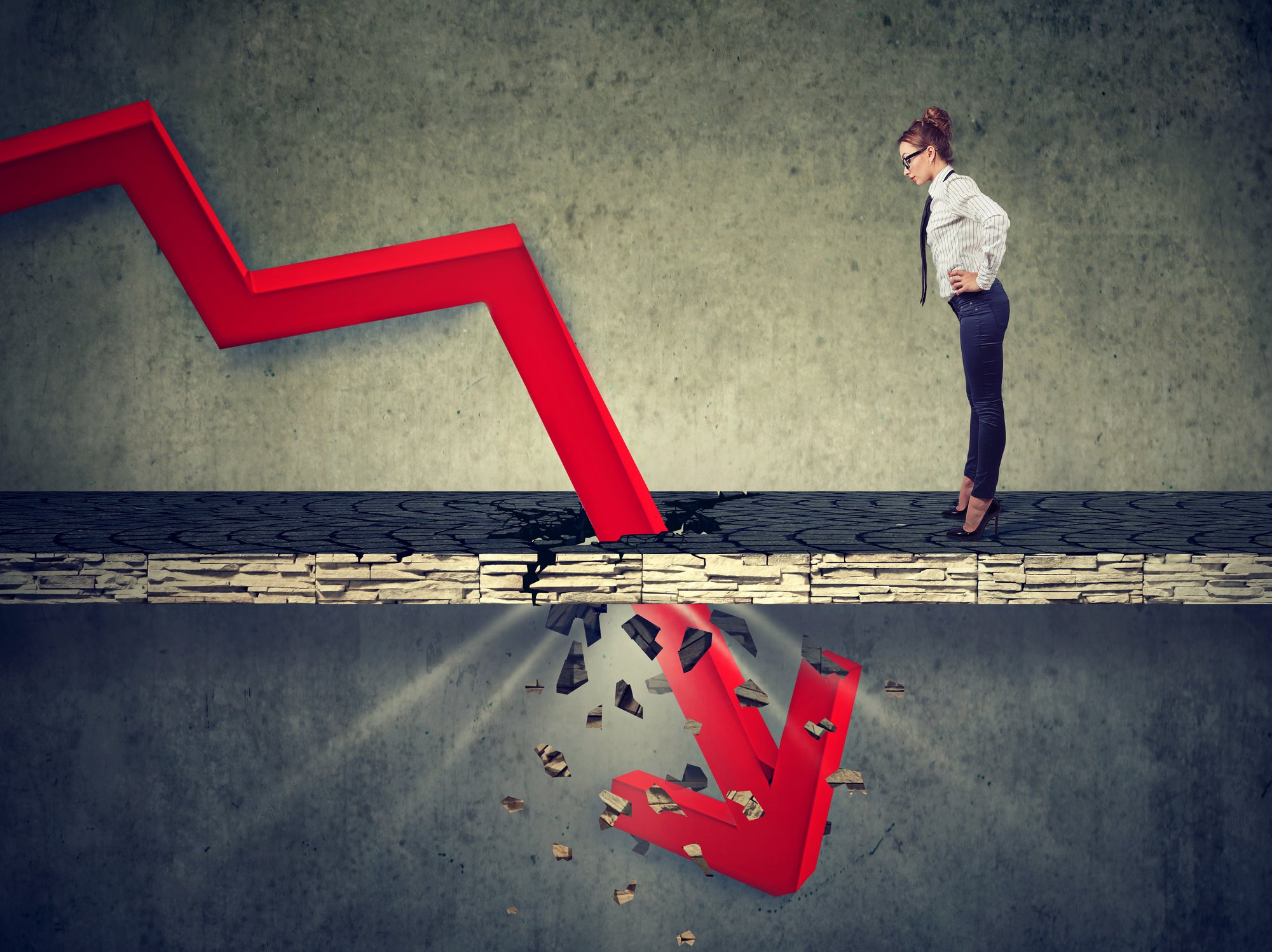 A woman looks down as the arrow at the end of a jagged red line crashes through the floor in front of her.