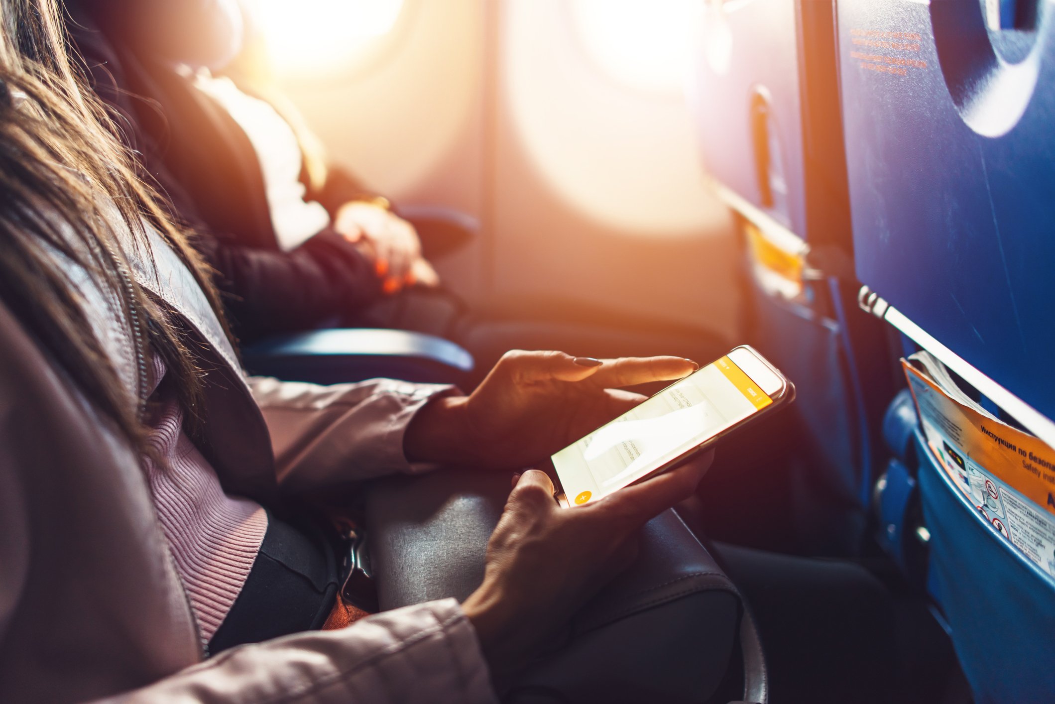 A woman using a tablet on an airplane