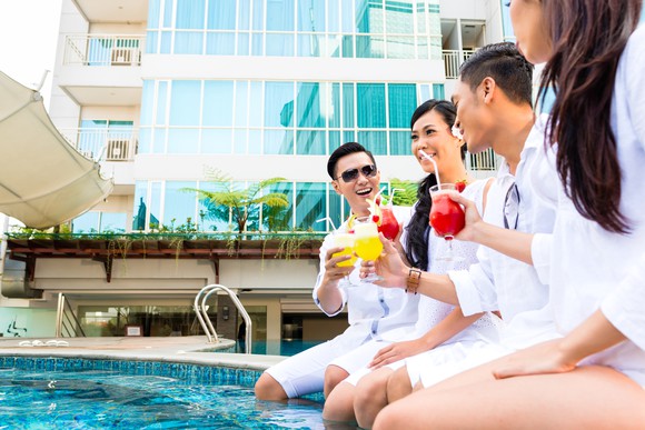 Two Chinese couples have drinks next to a pool.