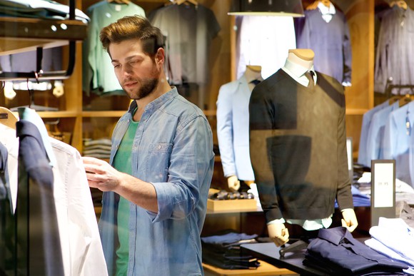 A man shopping for men's clothing in a department store.