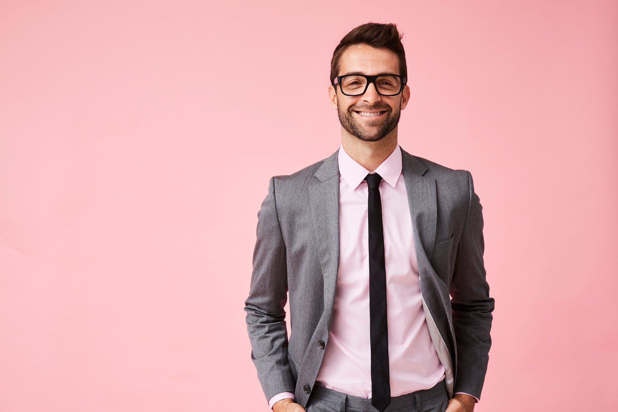 Smiling man in suit against pink background