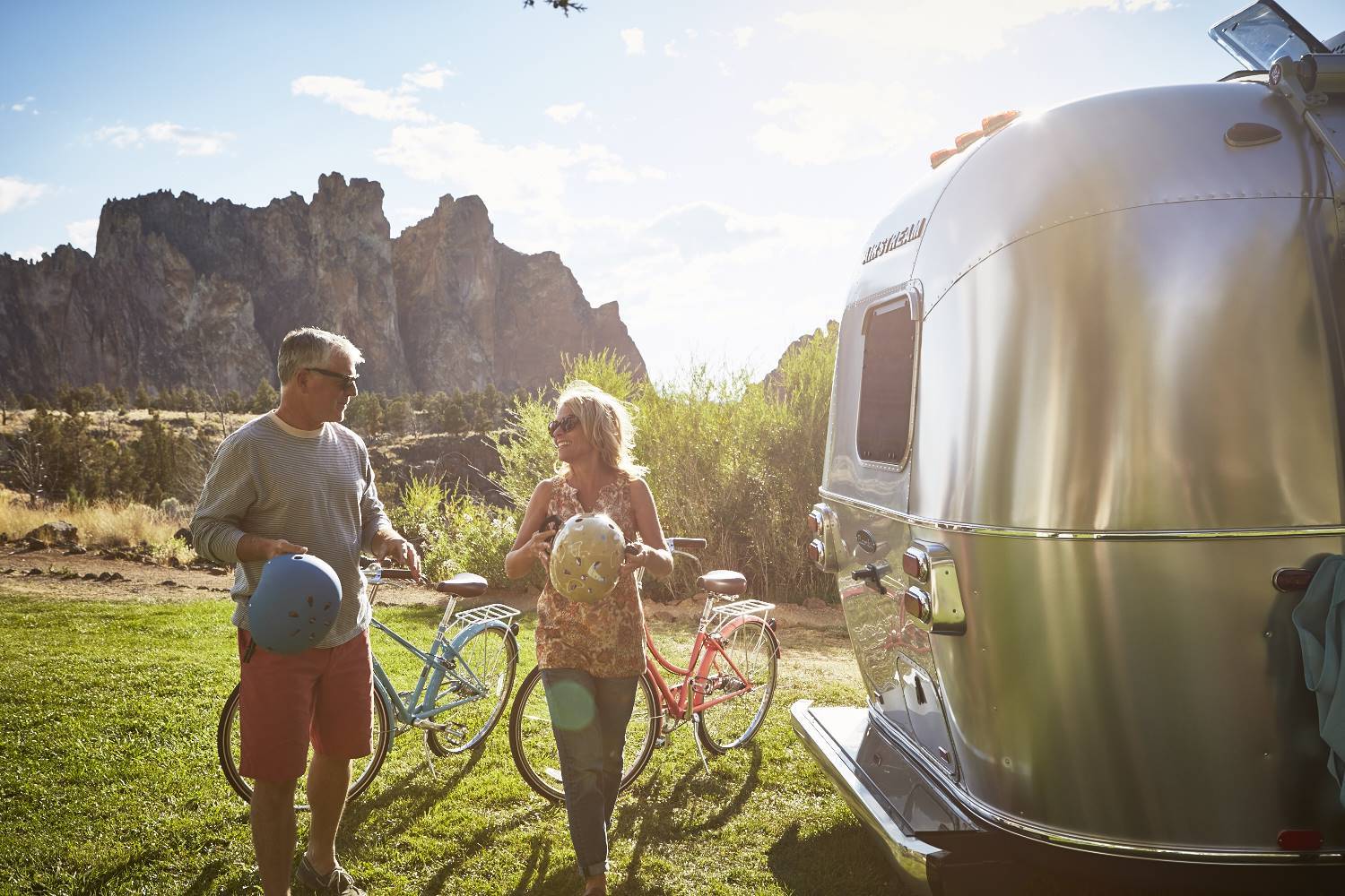 Metal Airstream camper with family and bicycles outside