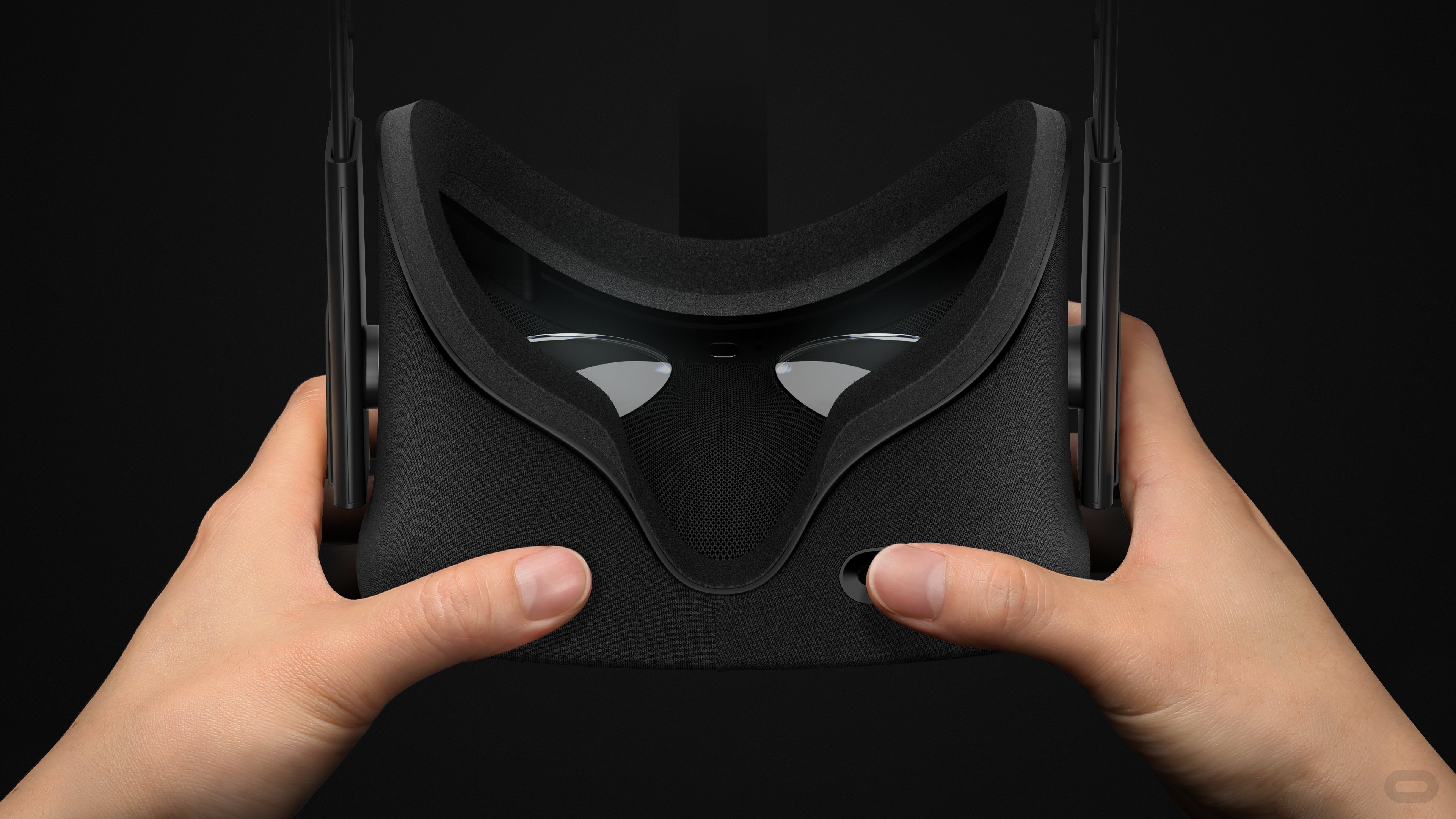 A pair of hands holds an Oculus headset.