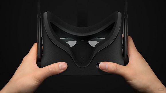 A pair of hands holds an Oculus headset.