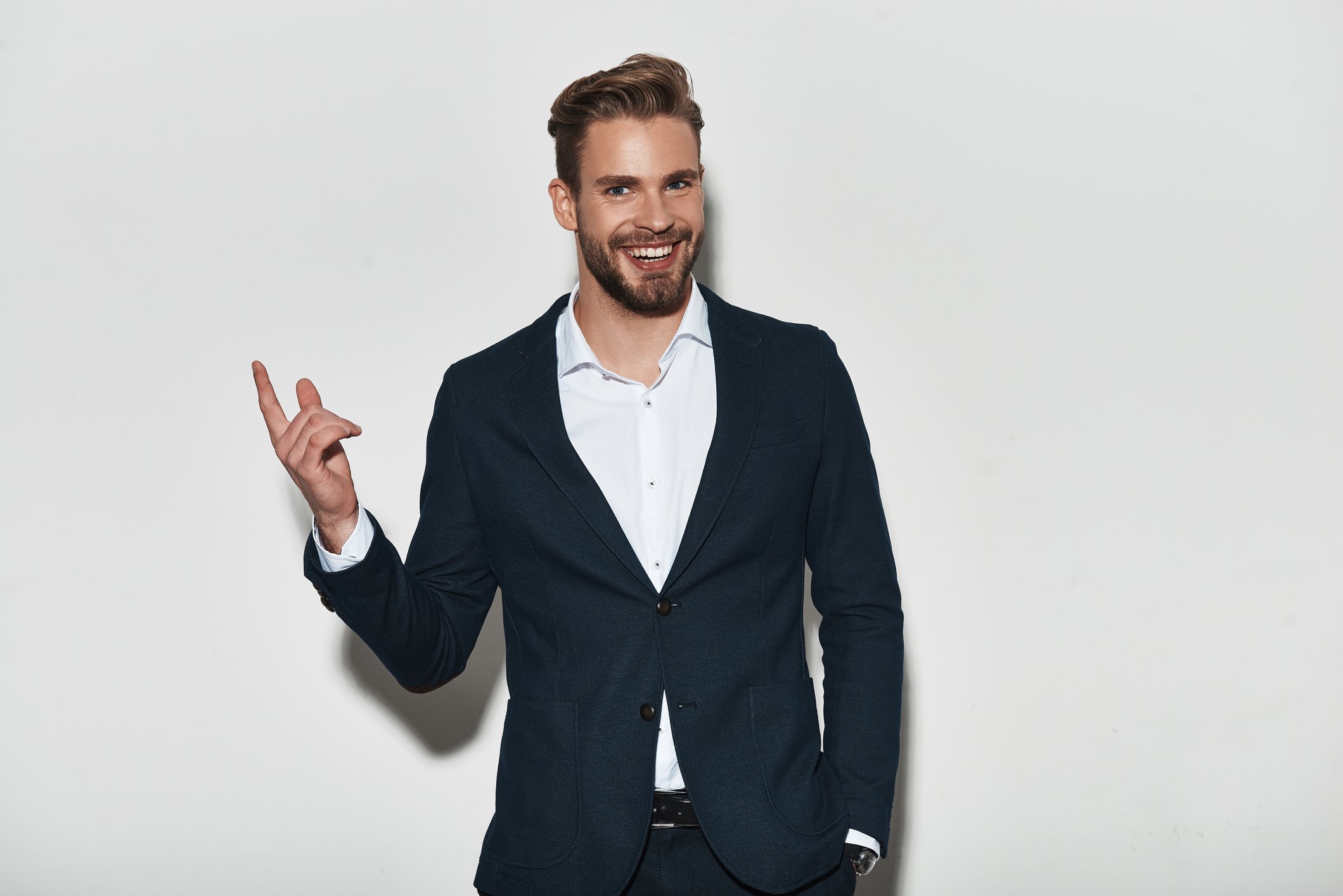 Smiling man in suit pointing upward