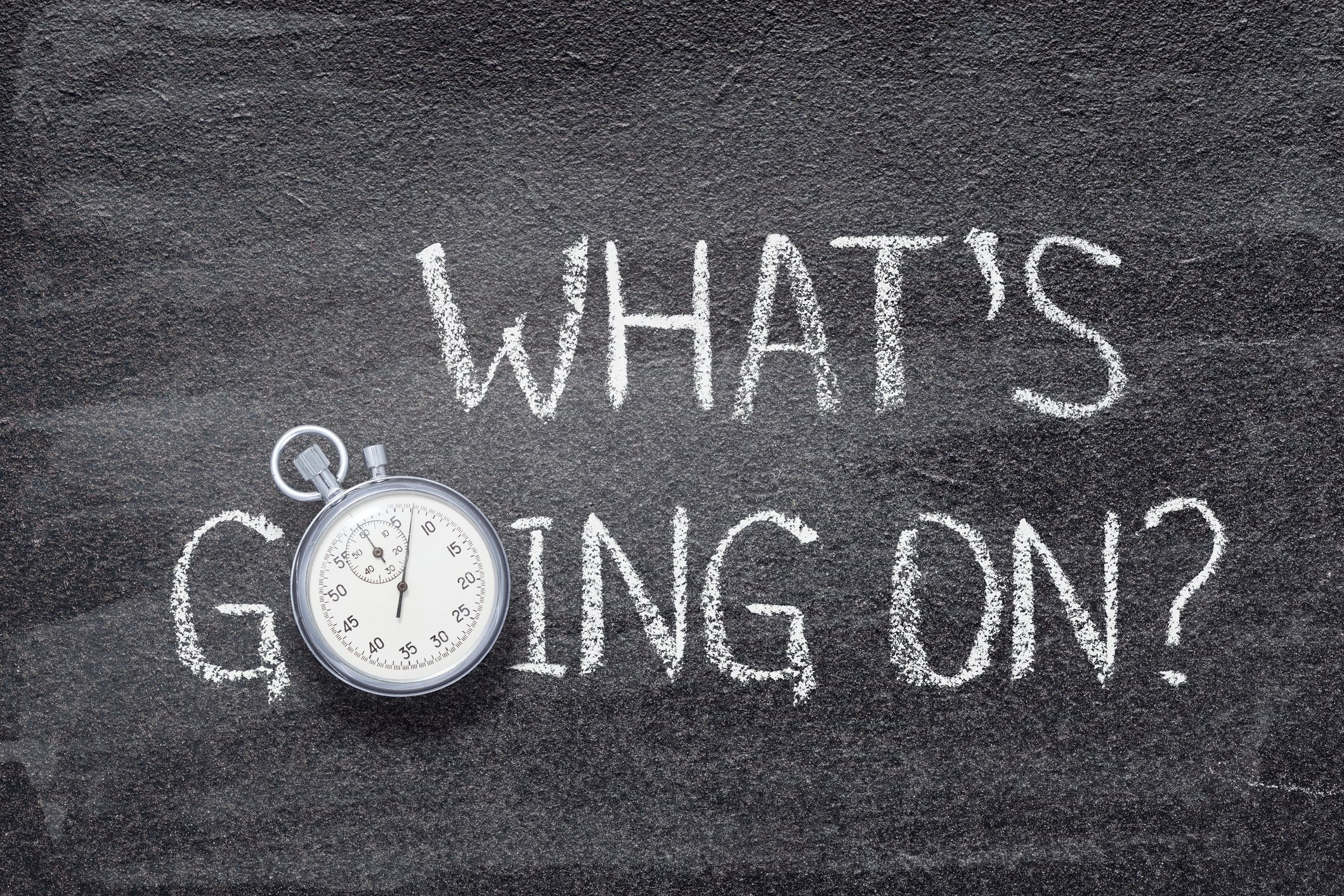 The question What's going on written on a chalkboard.