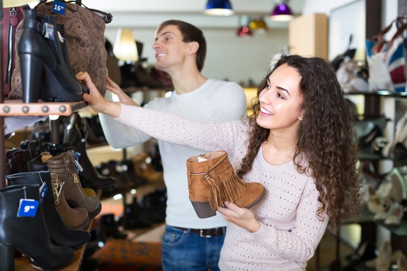 A young couple shops for shoes.