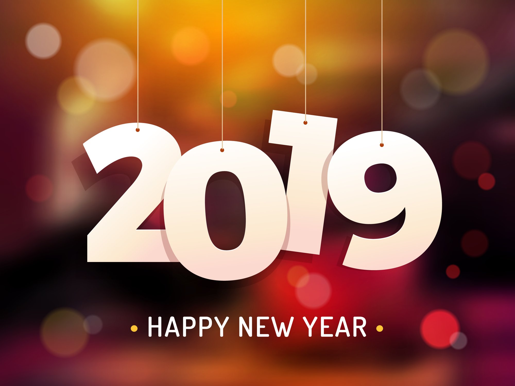 The numbers 2019 hanging from strings above the words happy new year.