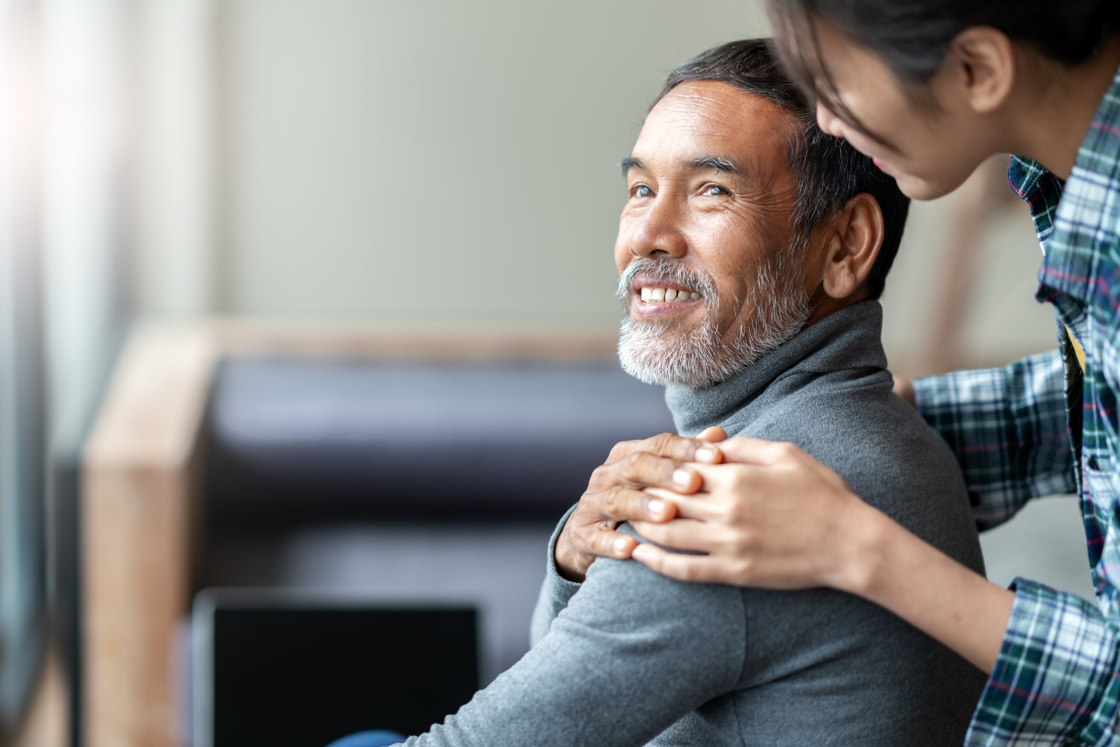 An older gentleman holding a woman's hand on his shoulder