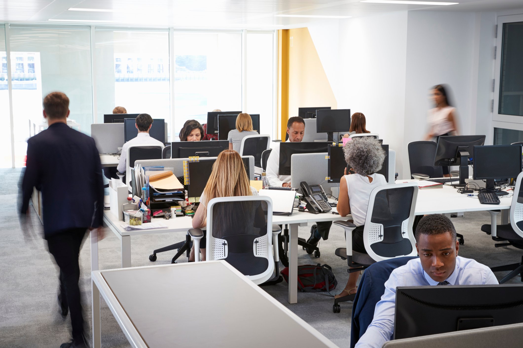 Office with rows of people at desks.