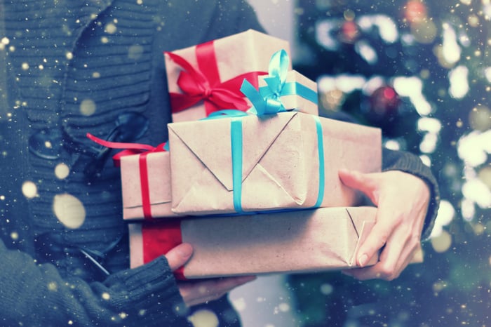 A person carries wrapped gifts.