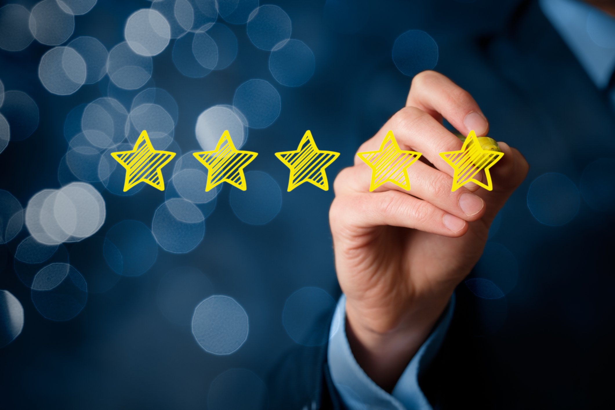 A person drawing five stars in a row