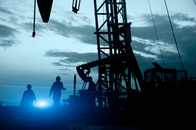 Oil workers near some oil pumps.