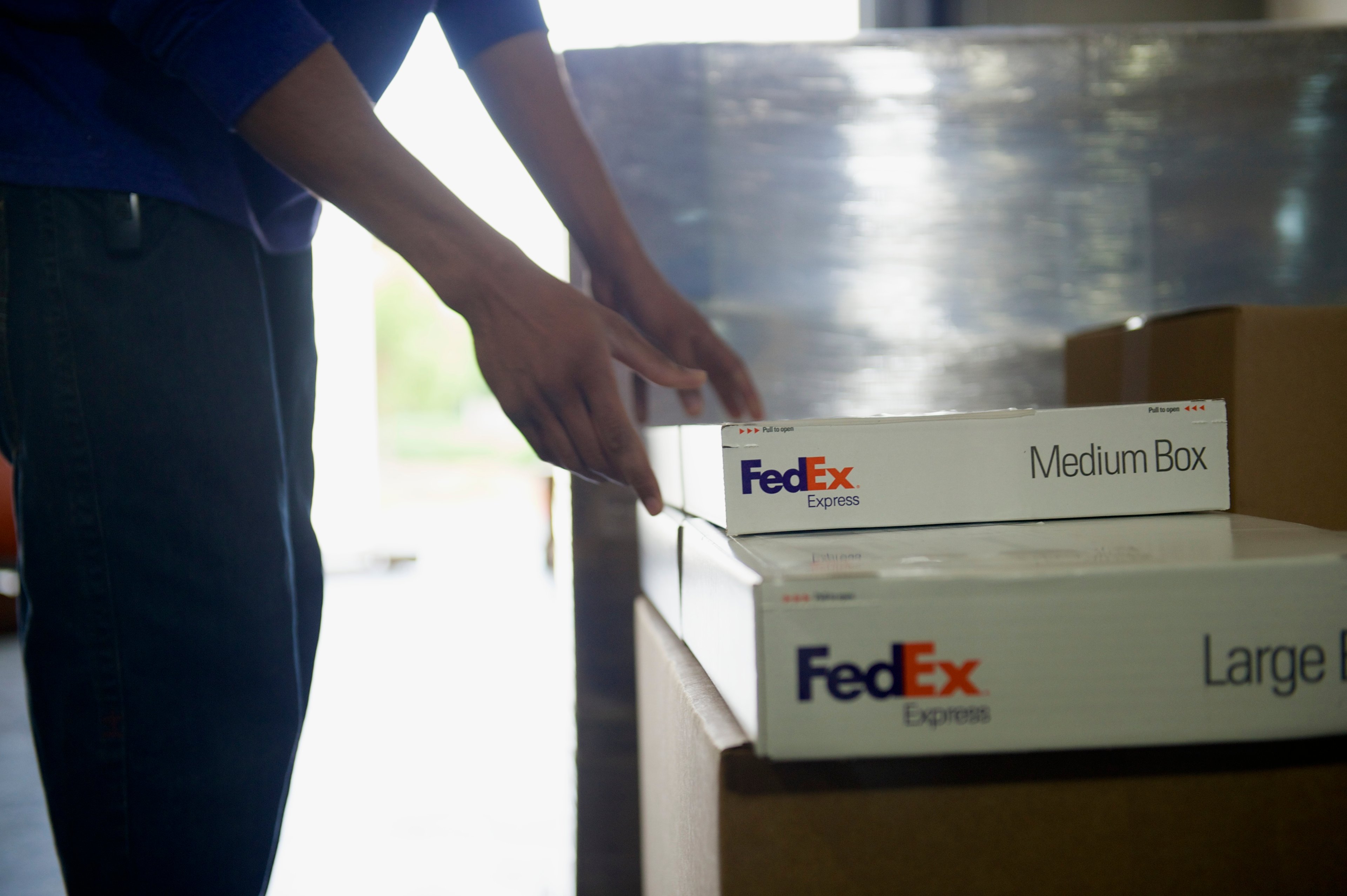 Worker moving FedEx Express boxes