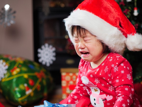 Child wear Santa hat crying