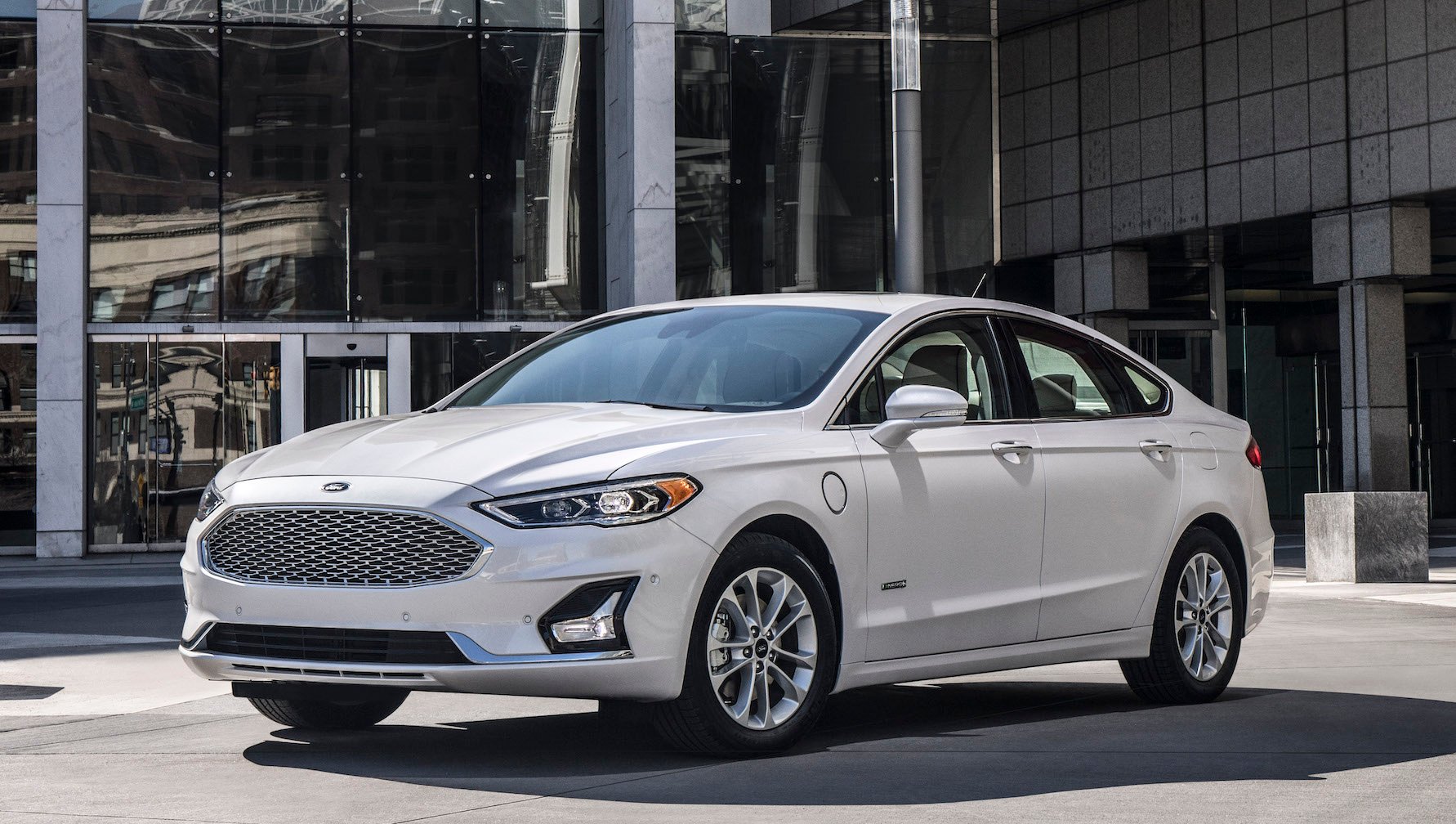A white Ford Fusion Hybrid, a midsize sedan.