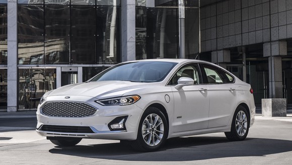A white Ford Fusion Hybrid, a midsize sedan.