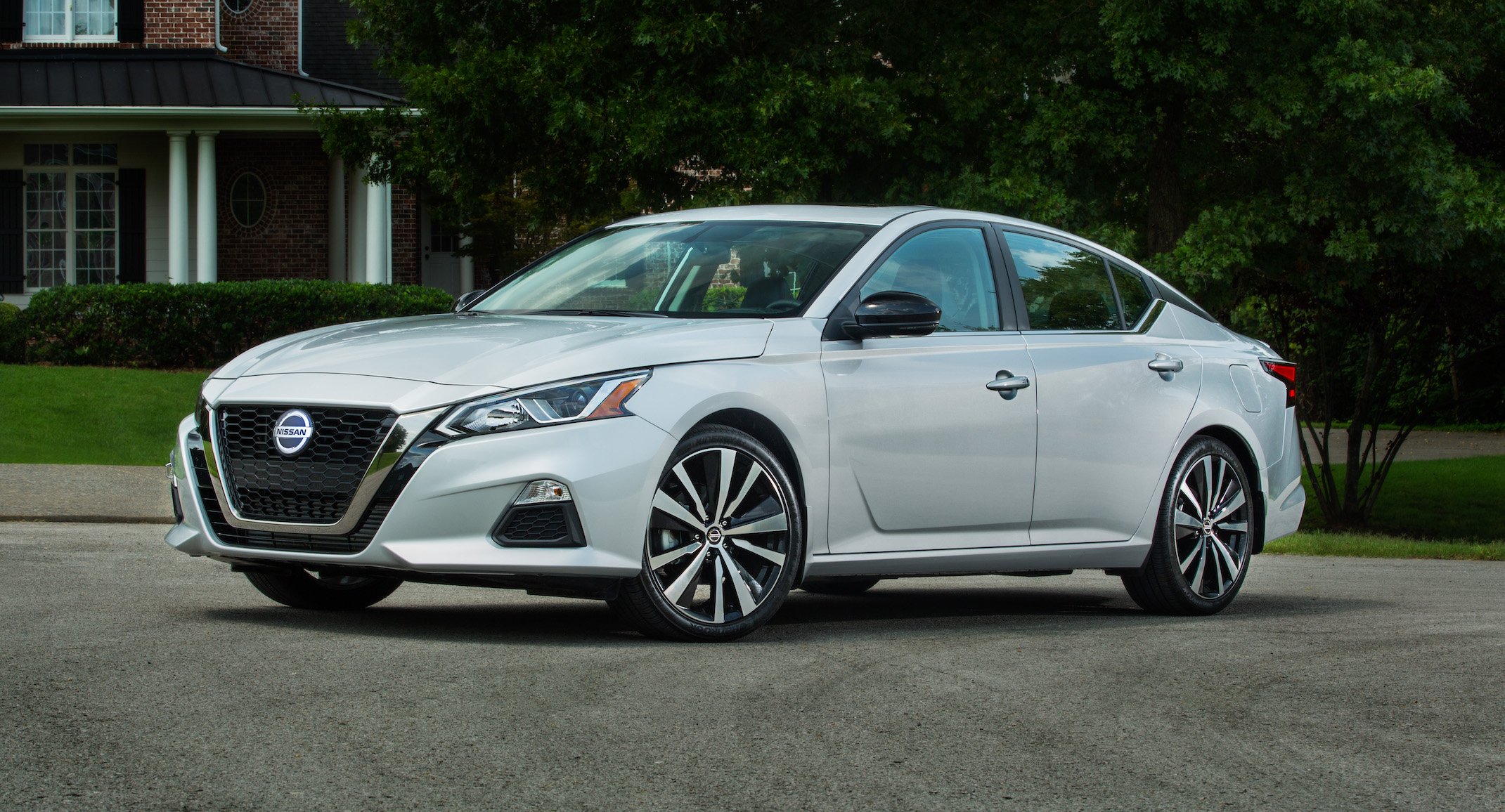 A white Nissan Altima, a midsize sedan.