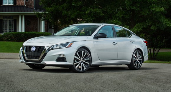 A white Nissan Altima, a midsize sedan.