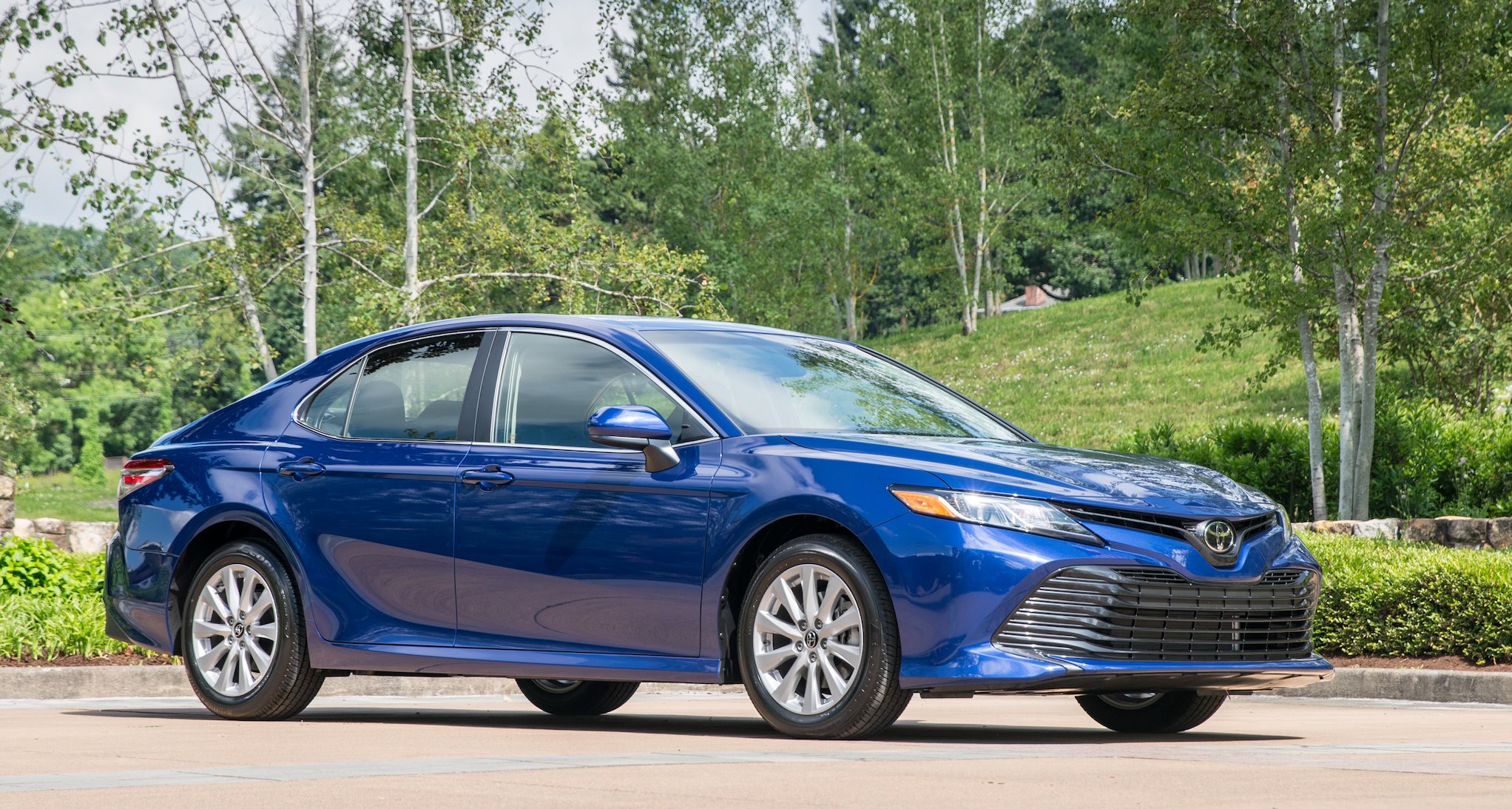 A blue Toyota Camry, a midsize sedan.