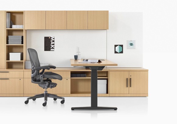 Contemporary chair next to a desk and shelving in wood.