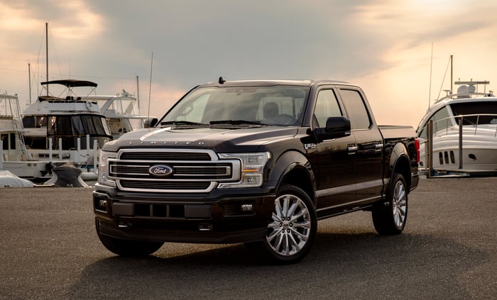 A black 2019 Ford F-150 Limited, an upscale full-size pickup truck, parked at a marina.
