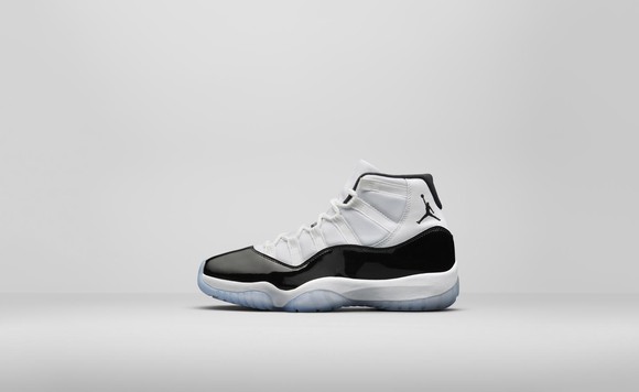 Air Jordan 11 Concord basketball shoe in white with a black patent leather stripe along the side.