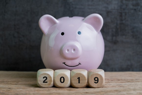 Pink piggy bank sitting behind 2019 spelled out in wooden cubes