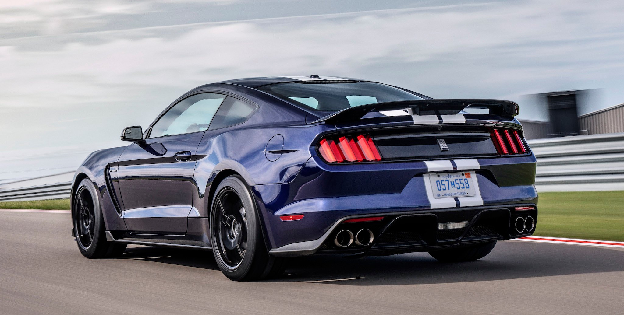 A dark-blue 2019 Ford Mustang Shelby GT 350, a high-performance coupe, on a racetrack. 