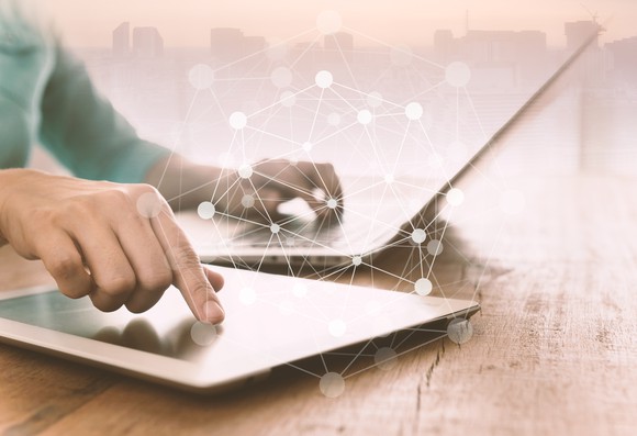 A person using a laptop and tablet.