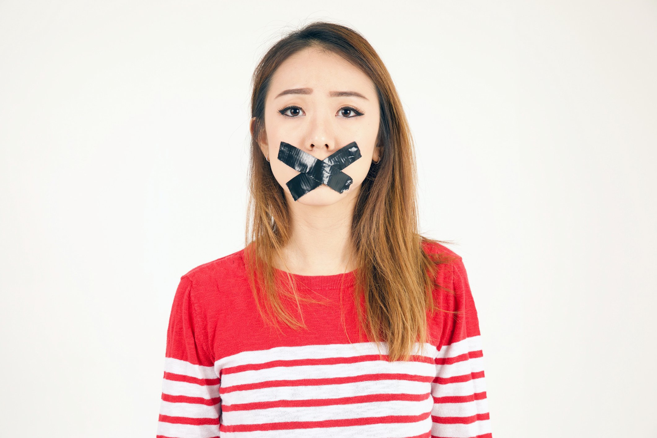 A young woman with tape on her mouth.