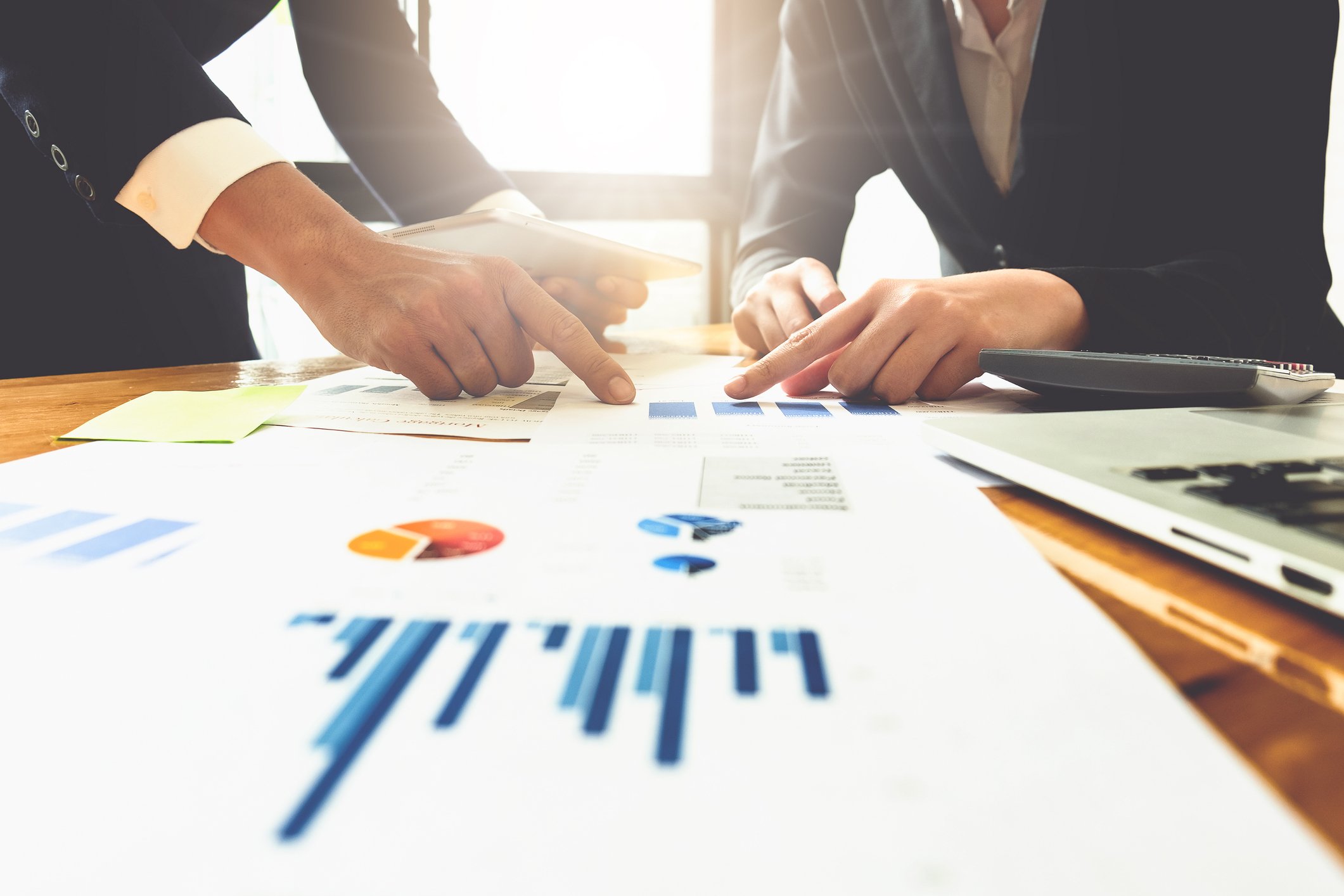 Businessmen pointing at charts and graphs