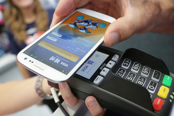 A smartphone placed on top of Visa card reader.