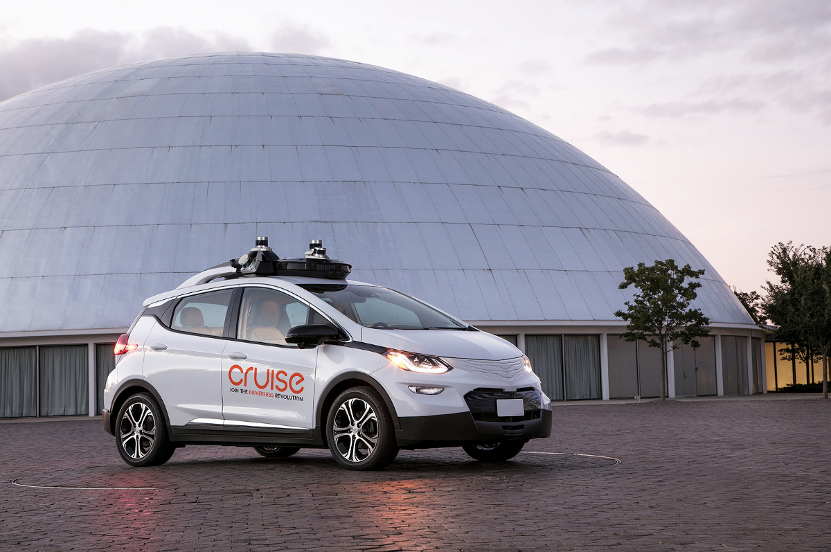 A GM Cruise self-driving vehicle, a white hatchback with visible self-driving hardware.