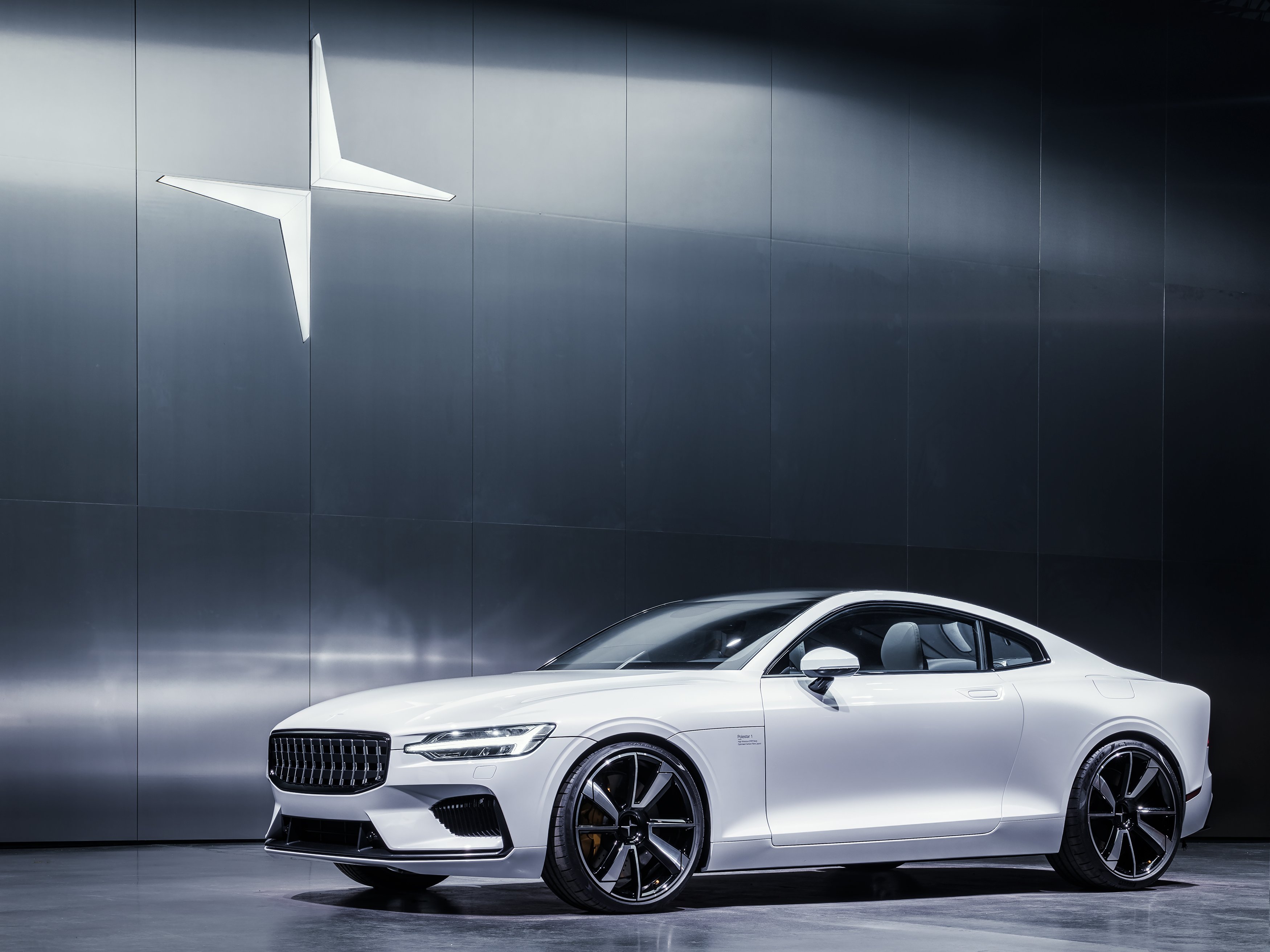 The two-door plug-in hybrid coupe Polestar 1, displayed in a showroom in white