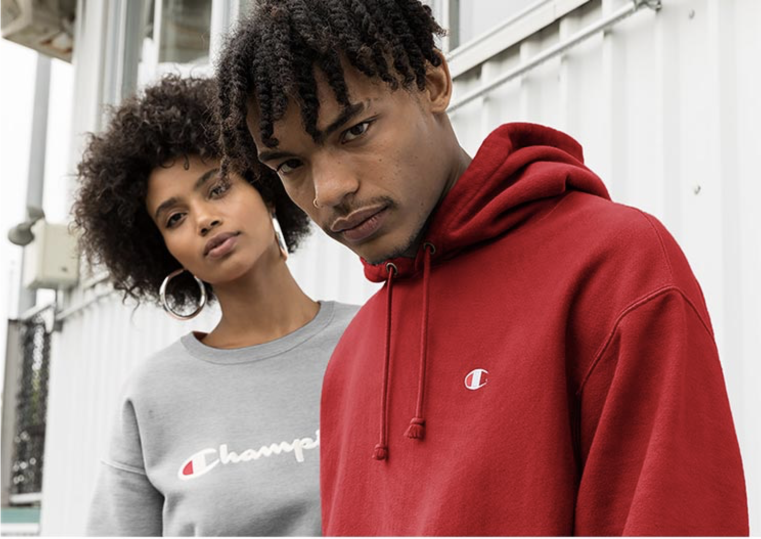 A man and woman wearing Champion brand sweatshirts.