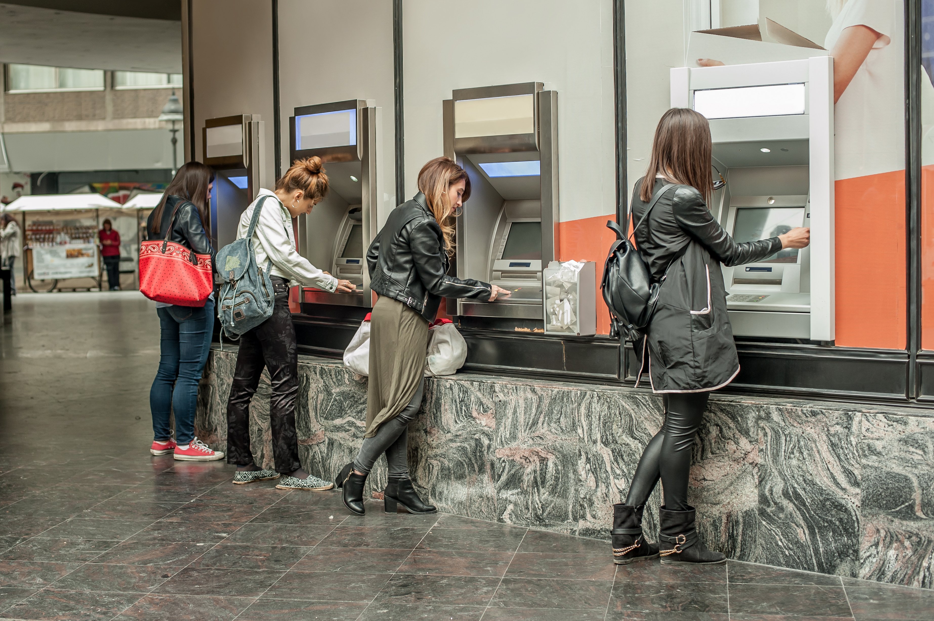 Four women using four ATMs