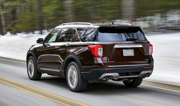 A dark red 2020 Ford Explorer Platinum on a snowy road, viewed from a rear three-quarter angle.