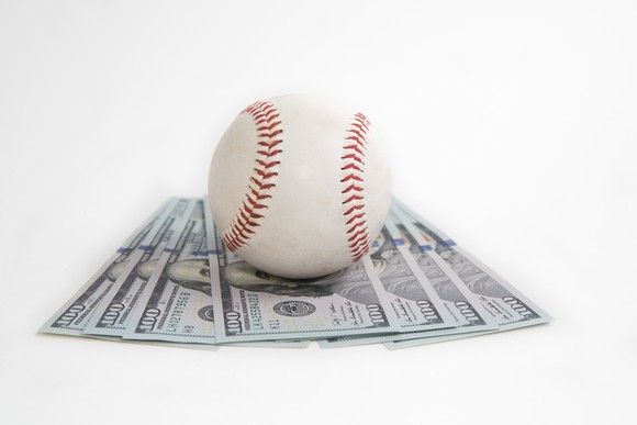 Baseball on top of $100 bills