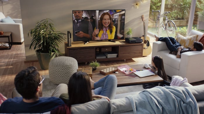 A family watching television on a living room TV.