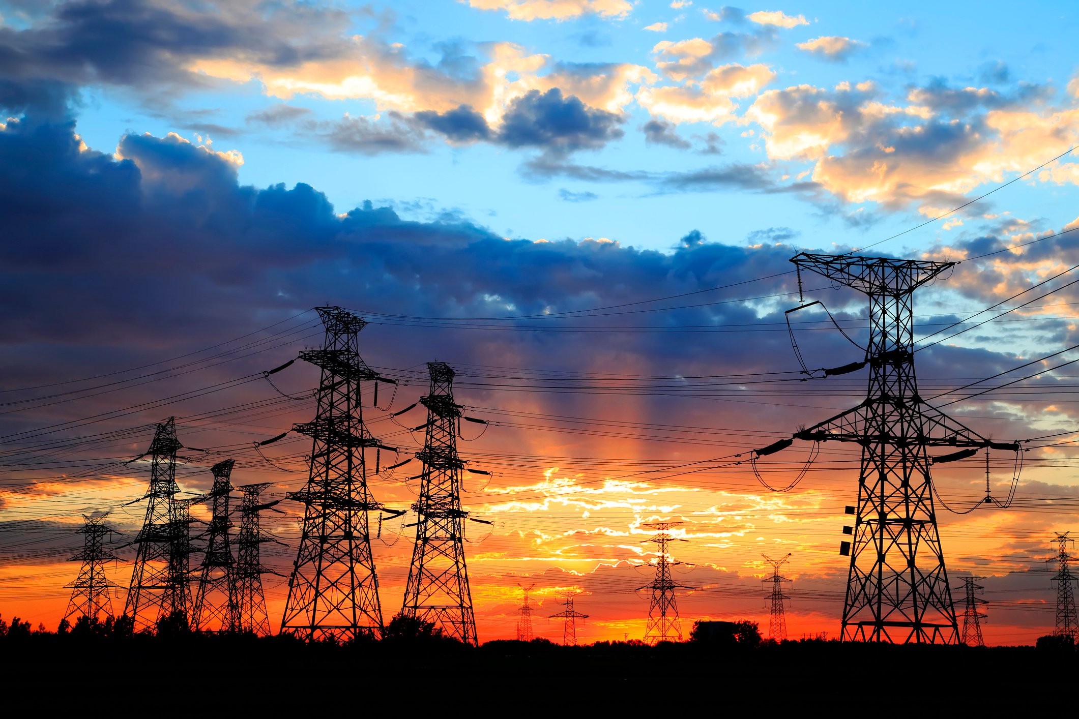 Power lines with partly cloudy skies at dusk. 