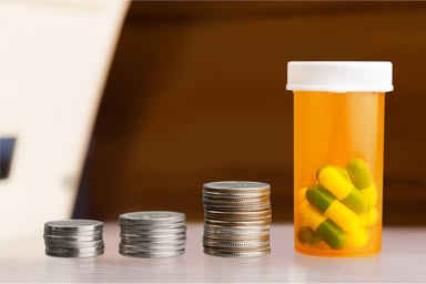 Stacks of coins with pill bottle