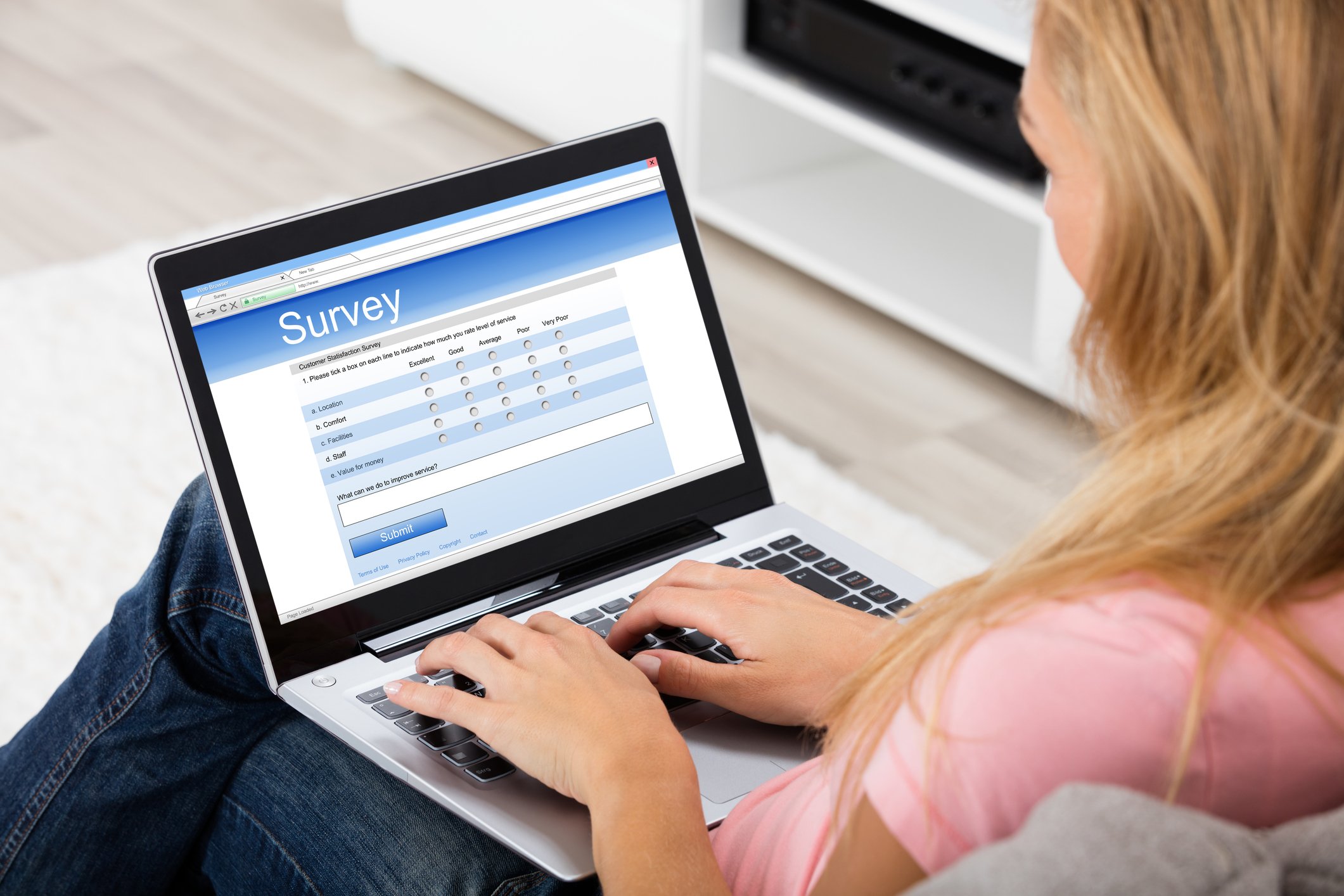 A woman responding to an online survey using a laptop.