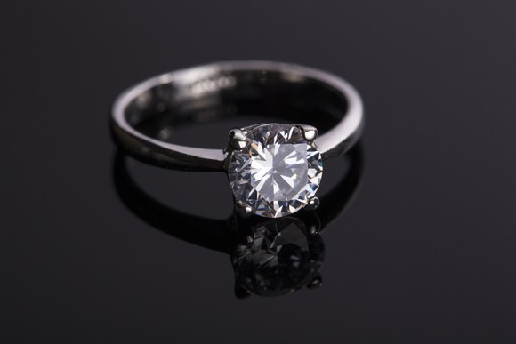 A diamond ring on a black surface